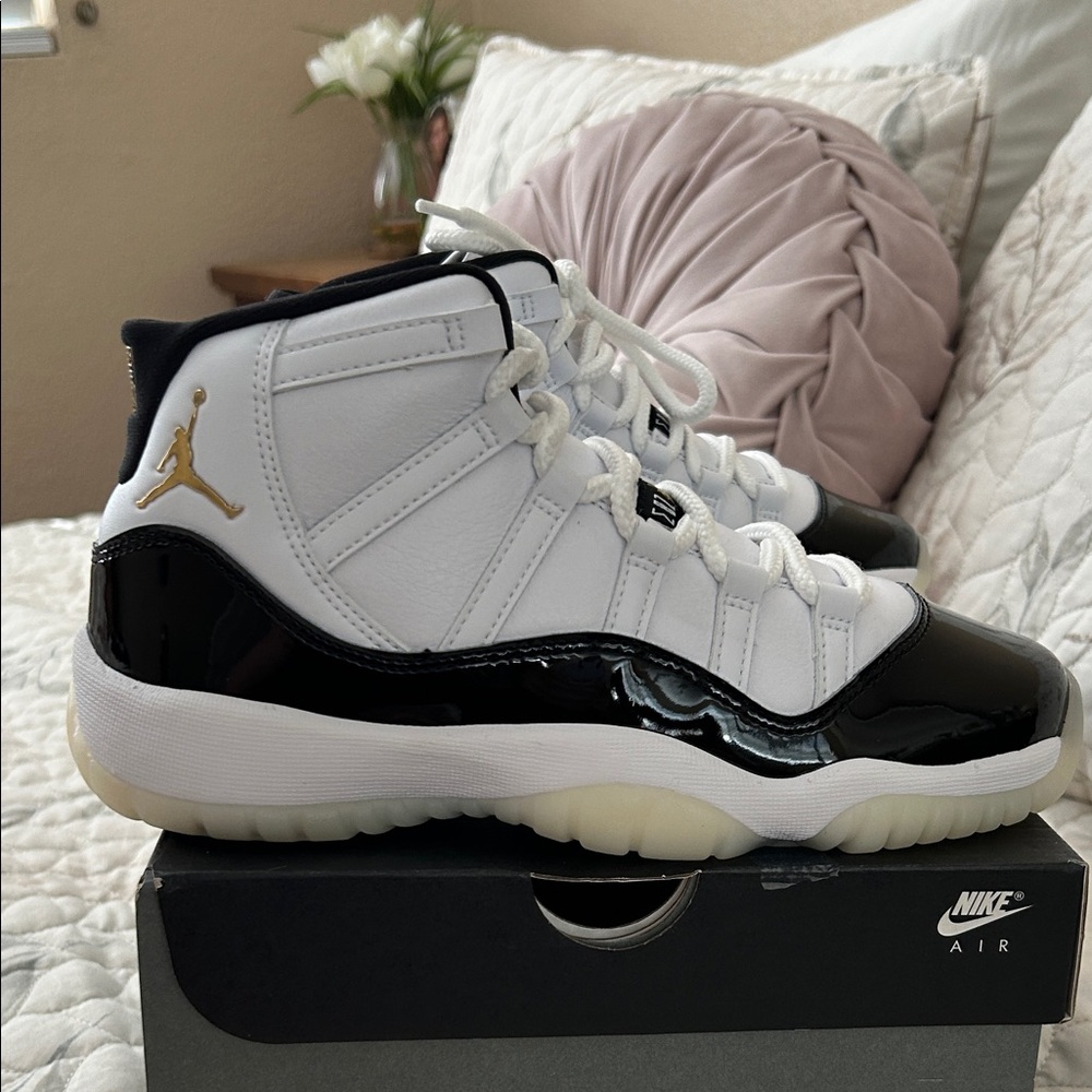 Nike Air Jordan 11 High-Top in White and Black with Gold Logo